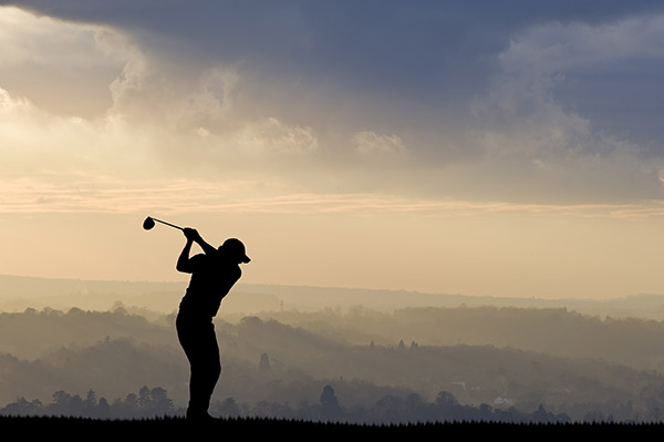 Golfsearcher | Golfer silhouette with driver against background with trees in fog